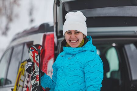 KAZKOVA POLYANA, UKRAINE - January 26, 2019: woman gathering to ski. car with opened trunk. parkingのeditorial素材