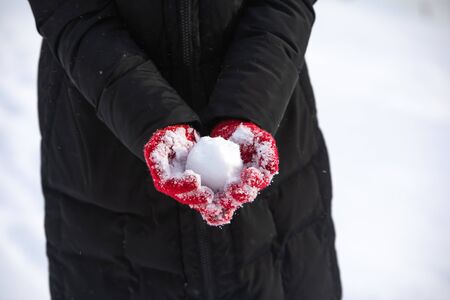 no face. snowball in woman hands in red winter glovesの販売画像