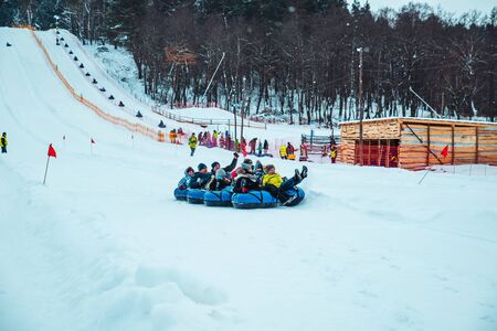 LVIV, UKRAINE - January 7, 2019: winter fun activities. ride down by hill on snow tubing. pushingのeditorial素材