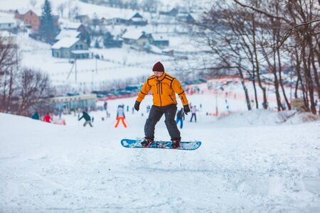 man snowboarding down by hill. winter sport time