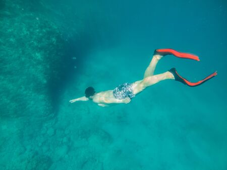 man in underwater in flippers looking at sea bottom summer beach vacation