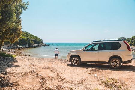 car travel concept man at summer beach looking at sea freedomの写真素材