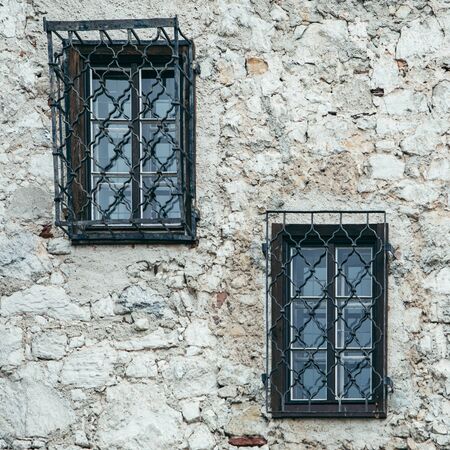 windows with metal shutters at gray stone building wall copy spaceの写真素材