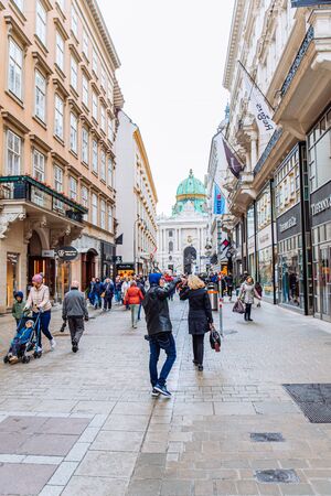 Vienna, Austria - May 16, 2018: Peterskirche church view people tourists walking buy spring european street. copy spaceのeditorial素材