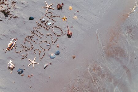 summer 2020 text on sand beach shells and starfish around. overheadの写真素材