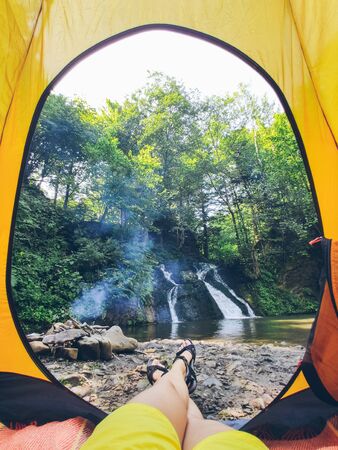 view from tent to the waterfall camping conceptの写真素材
