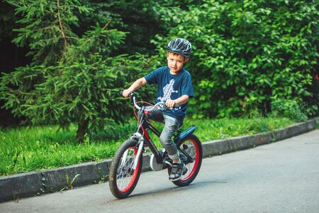 Lviv, Ukraine - June 23, 2019: little boy riding on bicycle in helmet in public parkのeditorial素材