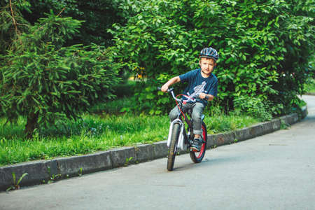 Lviv, Ukraine - June 23, 2019: little boy riding on bicycle in helmet in public parkのeditorial素材