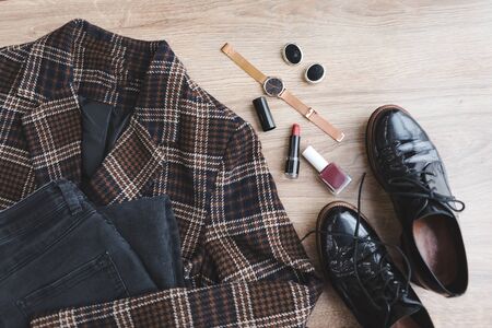 overhead top view of clothes blazer handbag jeans watch lipstick with nails polishの写真素材
