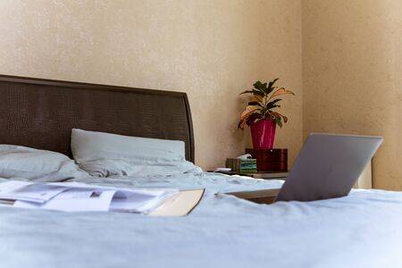 view of laptop with documents on bed. home work concept. isolation