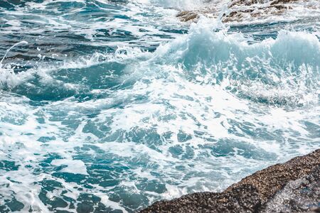 view of rocky seaside waves with white foam. copy spaceの写真素材
