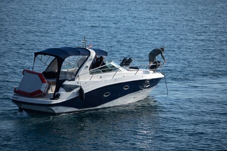 small motor speed boat in sea water with men. summer vacation