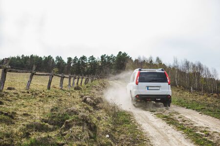 suv car riding by dusty country road. copy space