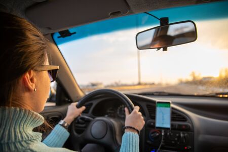 car travel concept sunrise at winter highway navigation on phone road tripの写真素材