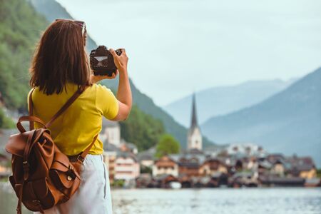 woman standing on the beach looking at hallstatt city copy spaceの写真素材