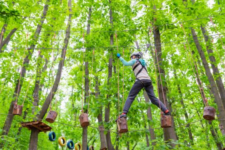 young sporty woman climbing in rope park. lifestyle