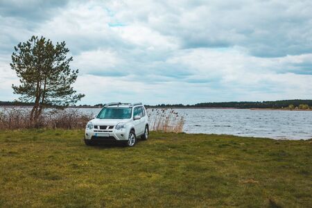white suv car at lake beach overcast weather. copy spaceの写真素材