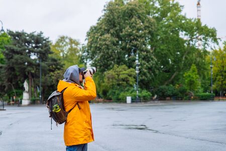 man with professional camera and big lens taking picture of the city architecture copy space tourismの写真素材