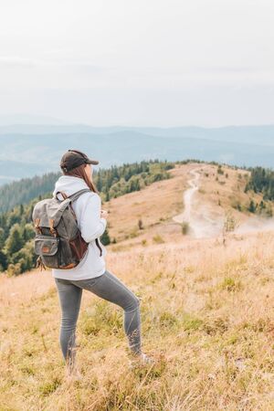 hiking concept woman with backpack at mountains peak autumn seasonの写真素材