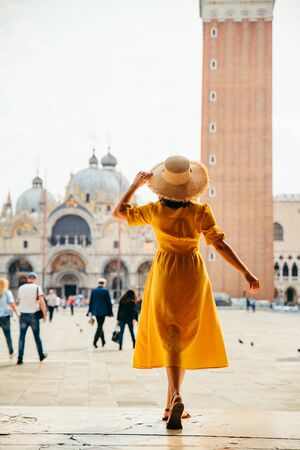 woman standing looking at saint marco piazza at sunny summer day bell tower saint marco basilicaの写真素材