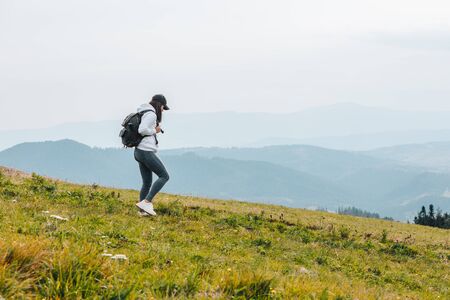 woman with backpack hiking in mountains autumn seasonの写真素材