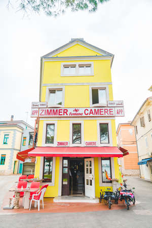 Umag, Croatia - June 6, 2019: view of yellow hostel building with outdoors cafe. copy space