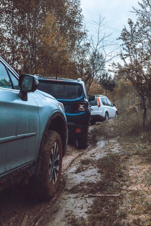 three suv cars at mud off road trail in forest. copy space