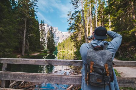 hiker man walking by path around mountain lake. summer leisure activities. vacation concept. copy...