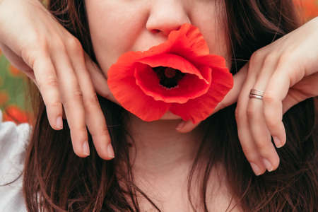 young stunning woman model posing with poppy flowers. close up