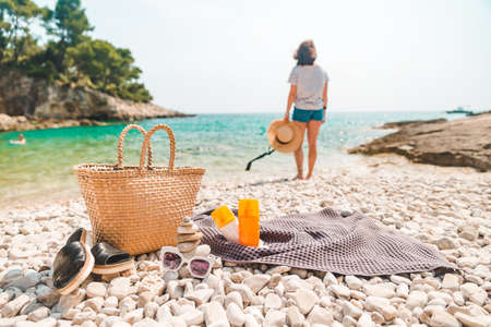 beach stuff straw hat and bag with flippers and sun protection creamの写真素材