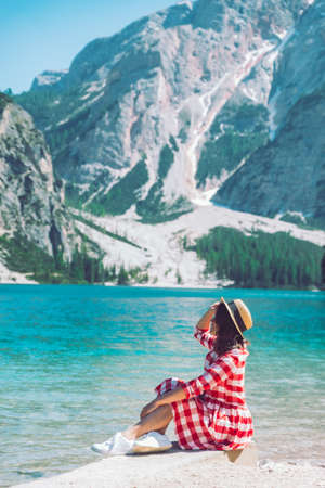woman sitting on the beach of mountain lake summer season scenic landscape viewの写真素材