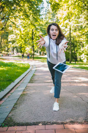 young woman let down mobile phone on stone ground
