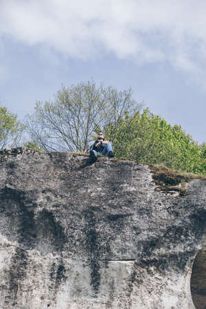 young hiker man on the top of the cliffの写真素材