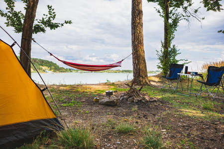 view of camping near lake with hammock between treesの写真素材