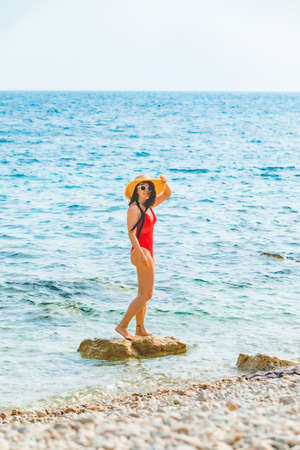 young pretty woman in straw hat at sea beachの写真素材