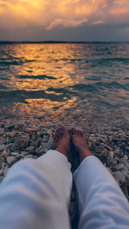 woman laying at the beach looking on sunset above seaの写真素材