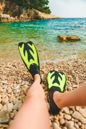 woman legs in flippers at beach sea on background copy space