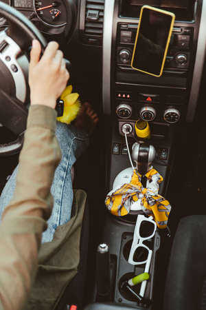 inside of the car with little women things sunglasses lipstick phone at phone holder. car travel...