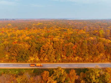 aerial view of autumn highway in forest copy space
