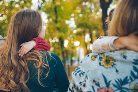 mother daughter love hug at autumn city park fall season