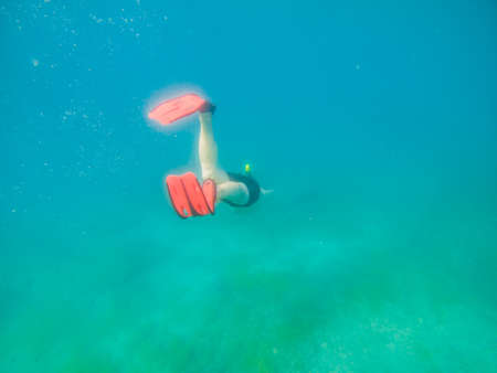 man swimming underwater with snorkeling musk summer sea vacationの写真素材