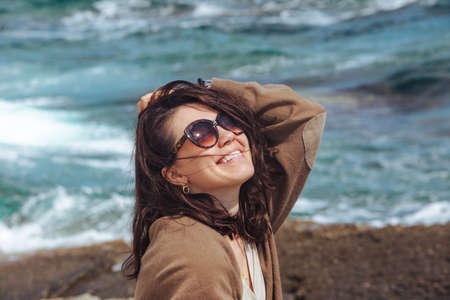 woman at sea beach enjoying power of nature. windy weather. summer vacation. waves on background