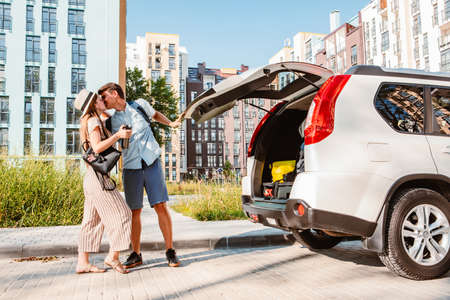 couple gathering for road trip. putting bags to car trunkの写真素材