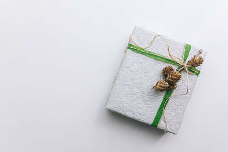 present gift box wrapped with white paper and green ribbon top viewの写真素材