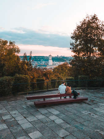 couple looking on sunset above the city autumn season