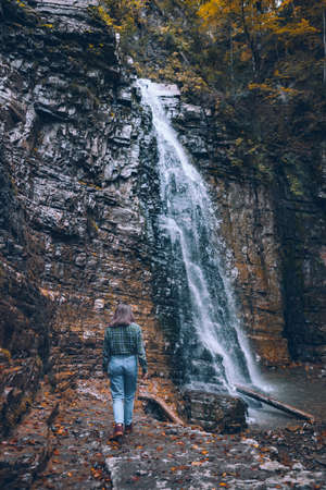 woman in casual clothes looking at waterfall copy spaceの写真素材