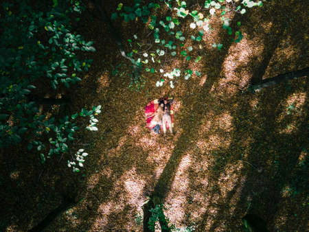 loving couple laying down on blanket in the middle of the forest