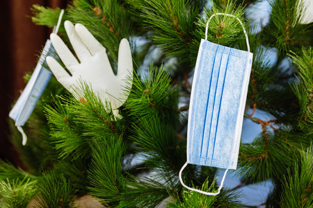 covid 2021 new year concept christmas tree decorated with gloves and medical maskの写真素材