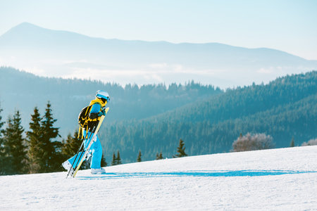 woman skiing down by winter slope mountains on backgroundの写真素材