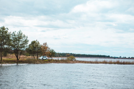 white suv car at lake beach overcast weather. copy spaceの写真素材